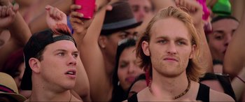 Movie still from “22 Jump Street” (2014), directed by Phil Lord – A man with long blonde hair is holding a drink; Close Up shot, Low angle