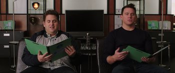 Movie still from “22 Jump Street” (2014), directed by Phil Lord – Two men sitting in front of a television; Medium shot, High angle