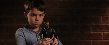 Movie still from “22 Jump Street” (2014), directed by Phil Lord – A young boy holding a toy in his hands; Close Up shot, Over the shoulder angle