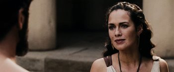 Movie still from “300” (2006), directed by Zack Snyder – A beautiful woman with long dark brown hair wearing a white dress; Close Up shot, Over the shoulder angle