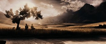 Movie still from “300” (2006), directed by Zack Snyder – A person sitting in a field under a cloudy sky; Extreme Wide shot, Low angle