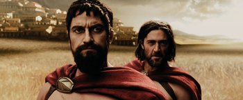 Movie still from “300” (2006), directed by Zack Snyder – Two men dressed in roman clothes and one is wearing a red cloth; Close Up shot, Low angle