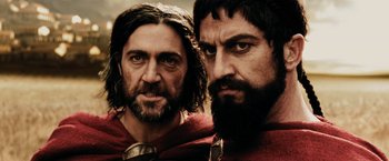 Movie still from “300” (2006), directed by Zack Snyder – Two bearded men are posing for a picture; Close Up shot, Low angle
