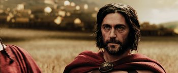 Movie still from “300” (2006), directed by Zack Snyder – A person with a beard wearing a cape; Close Up shot, Low angle