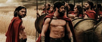 Movie still from “300” (2006), directed by Zack Snyder – A group of men in roman garb are standing in a field; Medium shot, Low angle