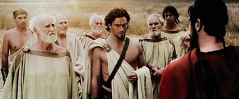 Movie still from “300” (2006), directed by Zack Snyder – A group of men standing next to each other in a field; Medium shot, Over the shoulder angle