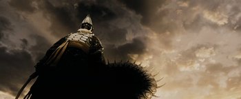 Movie still from “300” (2006), directed by Zack Snyder – A statue of a man in a suit and a hat; Wide shot, Low angle