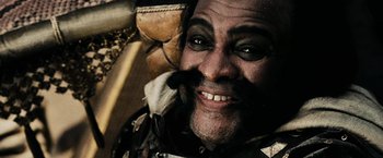 Movie still from “300” (2006), directed by Zack Snyder – A man with a beard and mustache smiling for the camera; Close Up shot, Low angle