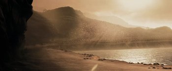 Movie still from “300” (2006), directed by Zack Snyder – A sandy beach near a body of water with mountains in the background; Extreme Wide shot, High angle