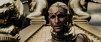 Movie still from “300” (2006), directed by Zack Snyder – A man with a lot of jewelry around his neck; Close Up shot, High angle