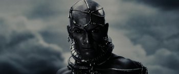Movie still from “300” (2006), directed by Zack Snyder – A man wearing a metal head piece with chains around his head; Close Up shot, Low angle