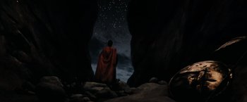 Movie still from “300” (2006), directed by Zack Snyder – A man in a red robe sitting in a cave; Extreme Wide shot, Low angle