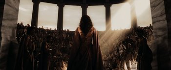 Movie still from “300” (2006), directed by Zack Snyder – A woman standing in front of a group of people; Wide shot, High angle