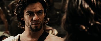 Movie still from “300” (2006), directed by Zack Snyder – A person with long black hair; Close Up shot, Over the shoulder angle