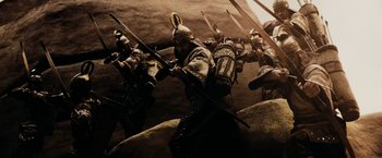 Movie still from “300” (2006), directed by Zack Snyder – A group of men in ancient roman armor and helmets; Wide shot, Low angle