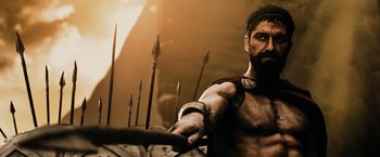 Movie still from “300” (2006), directed by Zack Snyder – A man with a beard holding a sword in his hand; Medium shot, Low angle
