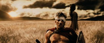 Movie still from “300” (2006), directed by Zack Snyder – A man with a bandaged head is standing in a field; Close Up shot, Low angle