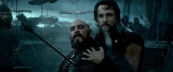 Movie still from “300: Rise of an Empire” (2014), directed by Noam Murro – Two men in black leather jackets one is holding a sword; Close Up shot, Over the shoulder angle