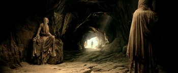 Movie still from “300: Rise of an Empire” (2014), directed by Noam Murro – A person is walking through a cave in the dark; Extreme Wide shot, High angle