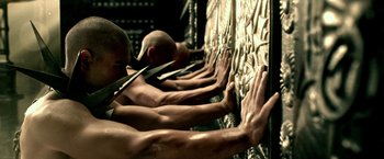 Movie still from “300: Rise of an Empire” (2014), directed by Noam Murro – A group of men holding onto a wall with their hands; Medium shot, Overhead angle