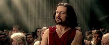 Movie still from “300: Rise of an Empire” (2014), directed by Noam Murro – A man with long hair and a beard wearing a red shirt; Close Up shot, Over the shoulder angle