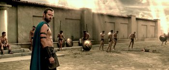 Movie still from “300: Rise of an Empire” (2014), directed by Noam Murro – A group of men are standing in the sand; Medium shot, Low angle