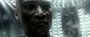 Movie still from “300: Rise of an Empire” (2014), directed by Noam Murro – A man's face in front of lights; Close Up shot, Over the shoulder angle