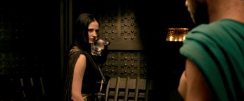 Movie still from “300: Rise of an Empire” (2014), directed by Noam Murro – A woman holding a sword in front of a wall; Medium shot, Over the shoulder angle