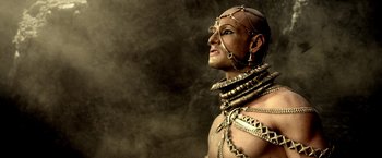 Movie still from “300: Rise of an Empire” (2014), directed by Noam Murro – A man in chains and a body suit is posing for a picture; Close Up shot, Low angle