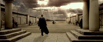 Movie still from “300: Rise of an Empire” (2014), directed by Noam Murro – A man walking down a street with a guitar case; Extreme Wide shot, Low angle