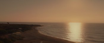Movie still from “365 Days: This Day” (2022), directed by Tomasz Mandes – A view of the ocean from the beach at sunset; Extreme Wide shot, High angle
