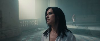A woman with long black hair is looking up