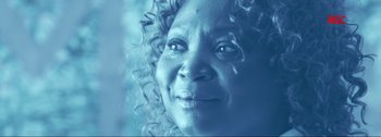 An older woman with curly hair and a smile on her face