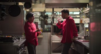 Movie still from “40 Years Young” (2022), directed by Pietro Loprieno – Two men in a kitchen talking to each other; Medium shot, Low angle