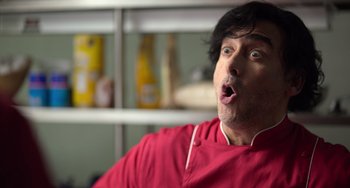 Movie still from “40 Years Young” (2022), directed by Pietro Loprieno – A man in a red shirt is making a funny face; Close Up shot, Low angle