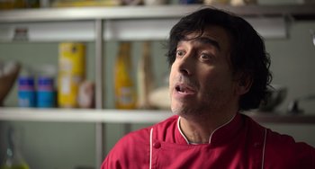 Movie still from “40 Years Young” (2022), directed by Pietro Loprieno – A man wearing a red shirt and a red apron; Close Up shot, Low angle