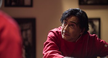 Movie still from “40 Years Young” (2022), directed by Pietro Loprieno – A person sitting in a room; Close Up shot, Low angle