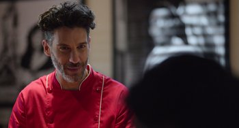 A man in a red shirt is talking to someone