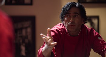 Movie still from “40 Years Young” (2022), directed by Pietro Loprieno – A man in a red shirt is gesturing with one hand; Close Up shot, Over the shoulder angle