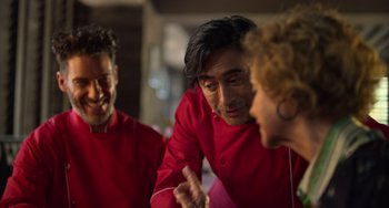 Movie still from “40 Years Young” (2022), directed by Pietro Loprieno – A group of people in red shirts talking to each other; Close Up shot, Over the shoulder angle