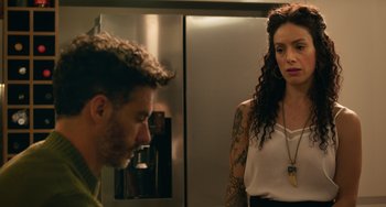 Movie still from “40 Years Young” (2022), directed by Pietro Loprieno – A man and a woman standing next to each other in front of a refrigerator; Close Up shot, Over the shoulder angle