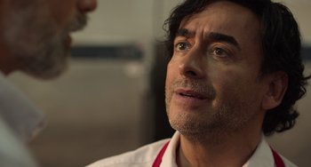 Movie still from “40 Years Young” (2022), directed by Pietro Loprieno – A person talking to another person; Close Up shot, Over the shoulder angle
