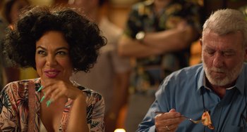 Movie still from “40 Years Young” (2022), directed by Pietro Loprieno – A woman sitting next to a man at a table; Close Up shot, Over the shoulder angle
