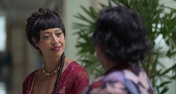 Movie still from “40 Years Young” (2022), directed by Pietro Loprieno – Two women talking to each other in front of a plant; Close Up shot, Over the shoulder angle