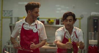 Movie still from “40 Years Young” (2022), directed by Pietro Loprieno – A couple of men standing next to each other in a kitchen; Medium shot, Low angle