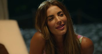 Movie still from “40 Years Young” (2022), directed by Pietro Loprieno – A beautiful woman with long brown hair smiling; Close Up shot, Over the shoulder angle