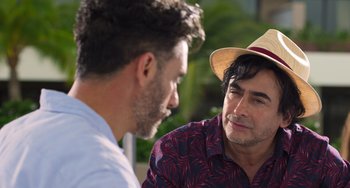 Movie still from “40 Years Young” (2022), directed by Pietro Loprieno – Two men talking to each other while wearing a hat; Close Up shot, Over the shoulder angle