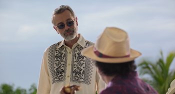 Movie still from “40 Years Young” (2022), directed by Pietro Loprieno – A man in a hat and sunglasses is looking at another man in a hat; Medium shot, Over the shoulder angle