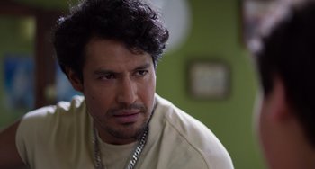 Movie still from “40 Years Young” (2022), directed by Pietro Loprieno – A person wearing a necklace; Close Up shot, Over the shoulder angle