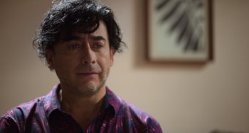 Movie still from “40 Years Young” (2022), directed by Pietro Loprieno – A person wearing a colorful shirt; Close Up shot, Over the shoulder angle